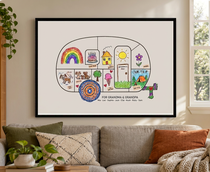 A finished gift mural shaped like a camper trailer, with kid-drawn pieces, hanging on a wall.